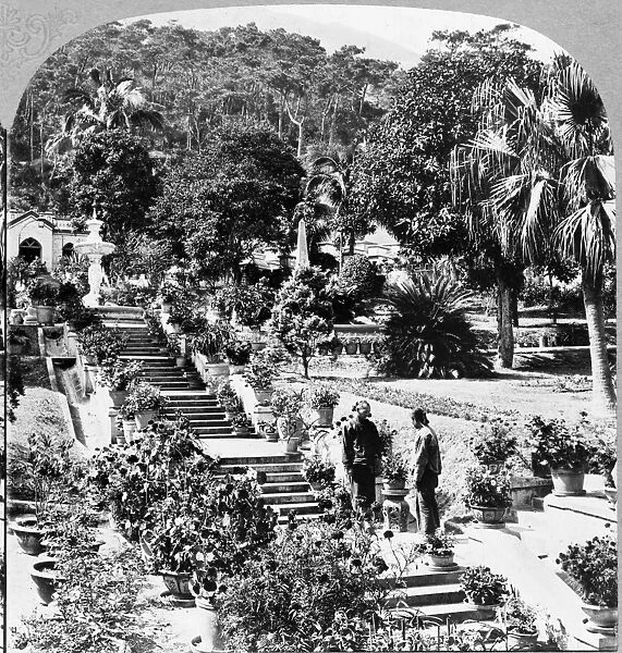 HONG KONG: CEMETERY, c1902. Two men on the steps that lead to a fountain in a landscaped