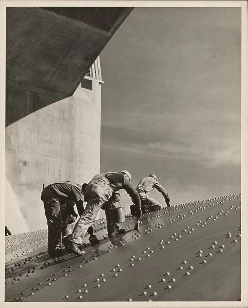 HOOVER DAM, c1940. Three construction workers applying a coat of paint on a riveted