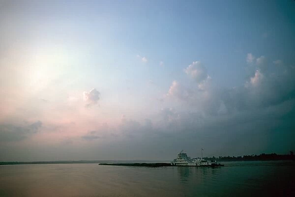 ILLINOIS: TOWBOAT. The Sally Archer, a towboat of the Archer Daniels Midland Company, pushing a barge at the confluence of the Ohio and Mississippi Rivers at Cairo, Illinois, at sunrise. Photographed c1974