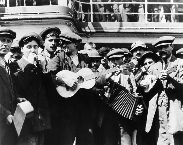 IMMIGRANT BAND, c1905. Immigrants bound for America form a makeshift band on the deck of a ship