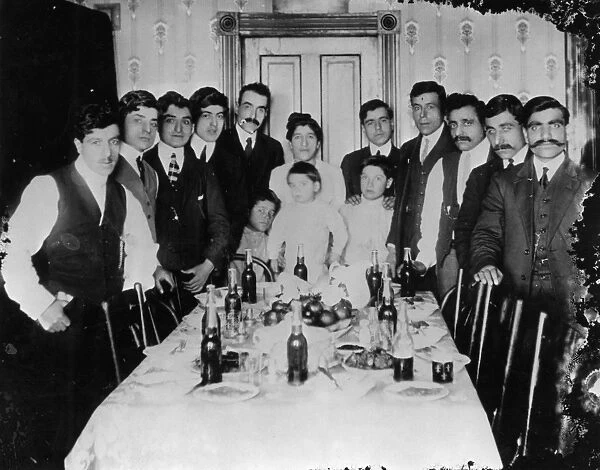 IMMIGRANT FAMILY, c1900. An immigrant family gathered around a dinner table, believed to be in St