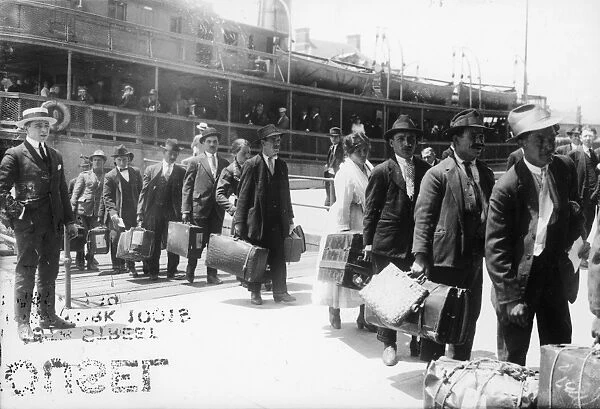 IMMIGRANTS, 1920. European immigrants leaving the Ellis Island ferry to arive in