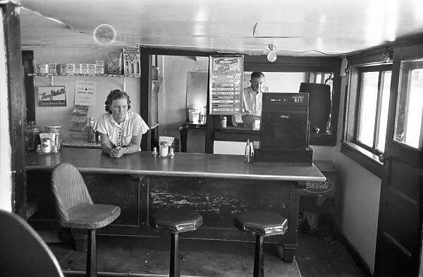 Interior of a food counter in a rural coffee shop in Alpine, Texas. Photograph by Russell Lee, May 1939