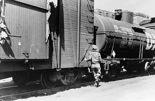 IOWA: FREIGHT TRAIN, 1940. A boy jumping a freight train, Dubuque, Iowa