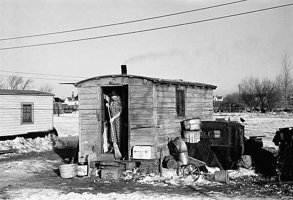 IOWA: SHANTYTOWN, 1936. Woman sweeping steps of her shack in a Shantytown in Spencer, Iowa