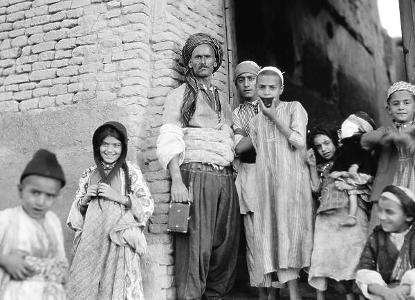 IRAQ: ARBELA, 1932. A man and children in Arbela (now Erbil), Iraq. Photograph, 1932