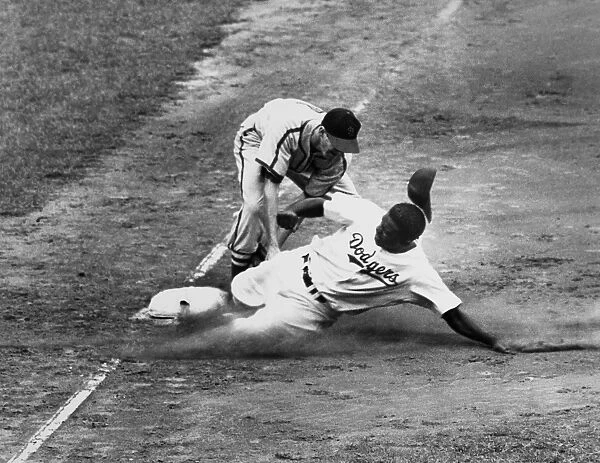 JACKIE ROBINSON (1919-1972). John Roosevelt Robinson, known as Jackie. American baseball player. As a member of the Brooklyn Dodgers, being tagged out at third base by shortstop Marty Marion of the St. Louis Cardinals during a game at Ebbets Field, Brooklyn, New York, 23 August 1949