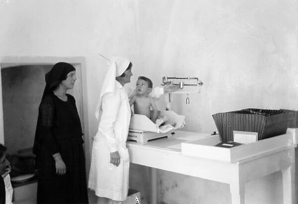 JERUSALEM: BABY CLINIC. A nurse weighing a baby at the Anna Spafford Baby Home in Jerusalem