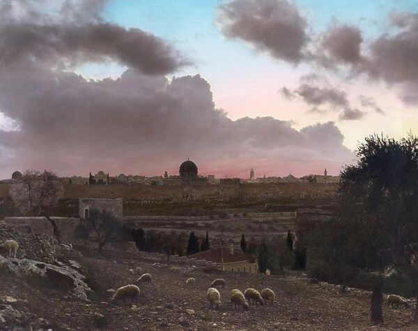 JERUSALEM, c1919. View of Jerusalem at sunset, with a flock of sheep in the foreground. Hand-colored photograph, c1919