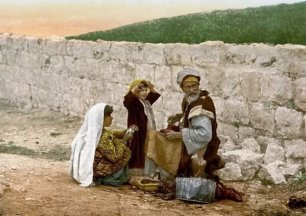 JERUSALEM SHOEMAKER, c1900. An elderly shoemaker at work in Jerusalem, shown with two girls. Photochrome, c1900