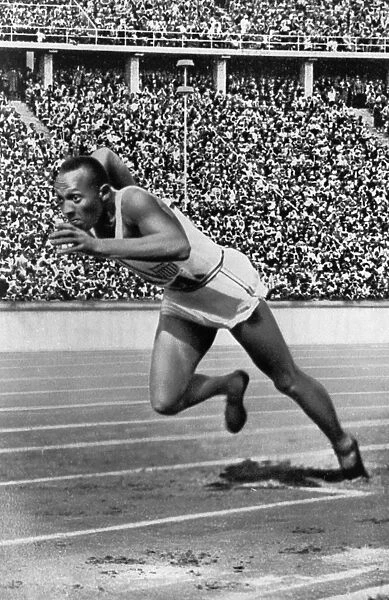 JESSE OWENS (1913-1980). American athlete. Photographed at the Olympic Games in Berlin, 1936, at the start of the 200 meter sprint final, which he won, setting an Olympic record