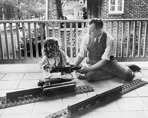 John N. Swartzell and his daughter, Margaret, playing with an electric train on the porch of their home in Washington, D. C. c1925