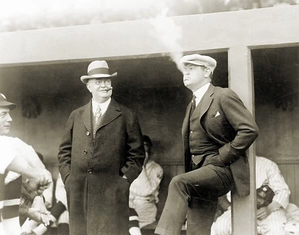 JOHNSON & RUTH, 1922. American baseball executive Ban Johnson (left) smoking cigars at a baseball game in Washington, D. C, with New York Yankees star Babe Ruth, 12 April 1922