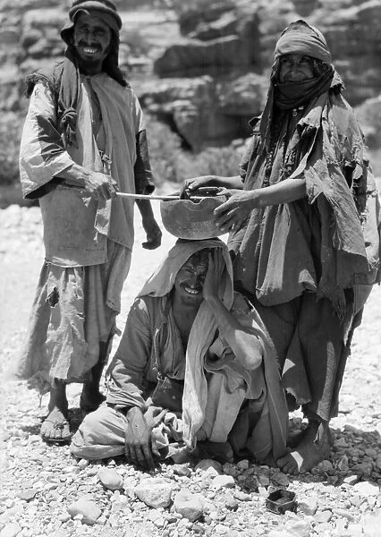 JORDAN: BEDOUIN RITUAL. Two Bedouins perform a healing ritual over a sick man, at Petra, Jordan