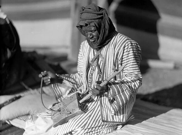 JORDAN: MUSICIAN. A black musician playing a one-stringed instrument in Jordan