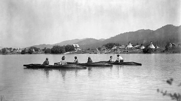 KALISPEL TRIBE, c1910. Native Americans in three canoes with their camp on the