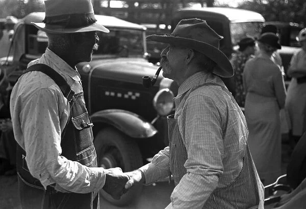 KANSAS: FARMERS, 1938. Two farmers shake hands at a farm auction in Oskaloosa, Kansas