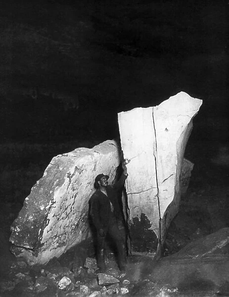 KENTUCKY: MAMMOTH CAVE. A man standing alongside standing rocks inside Mammoth Cave in Kentucky