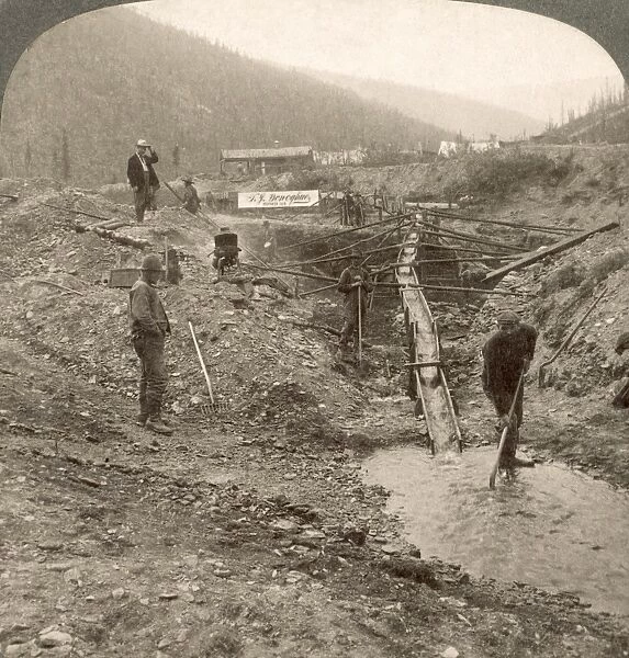 KLONDIKE GOLD RUSH. Miners working at a sluice box in Alaska. Stereograph view, c1898