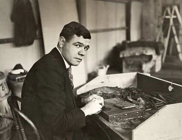 Known as Babe Ruth. American professional baseball player. Photographed rolling cigars, c1919