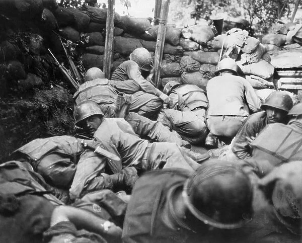 KOREAN WAR, 1950-1953. Infantrymen of the Second U. S. Division take cover from a Communist Chinese mortar barrage in a shallow pit