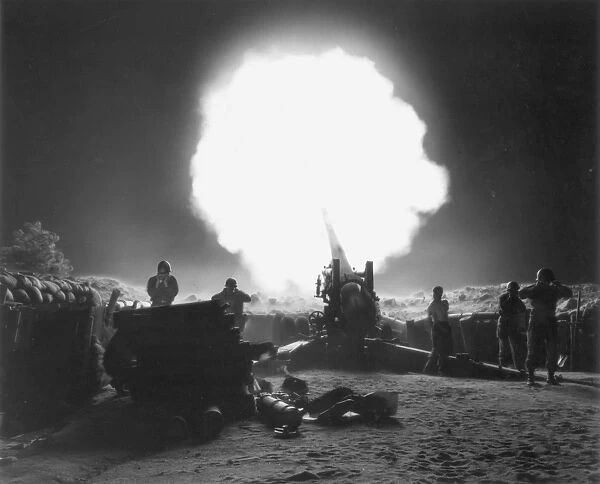 KOREAN WAR, 1952. A U. S. Army gun crew blasts off a howitzer at the enemy line somewhere along the Korean front, October 1952