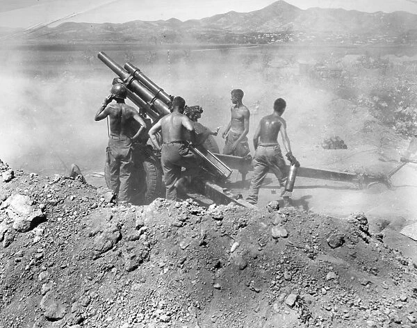 KOREAN WAR: ARTILLERY. U. S. artillerymen firing a 105mm howitzer on North Korean positions near Uirson, South Korea, August 1950