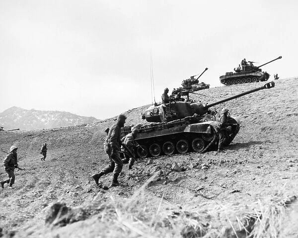 KOREAN WAR: INFANTRYMEN. American Infantrymen supported by tanks advance up a hill in Korea, 1952