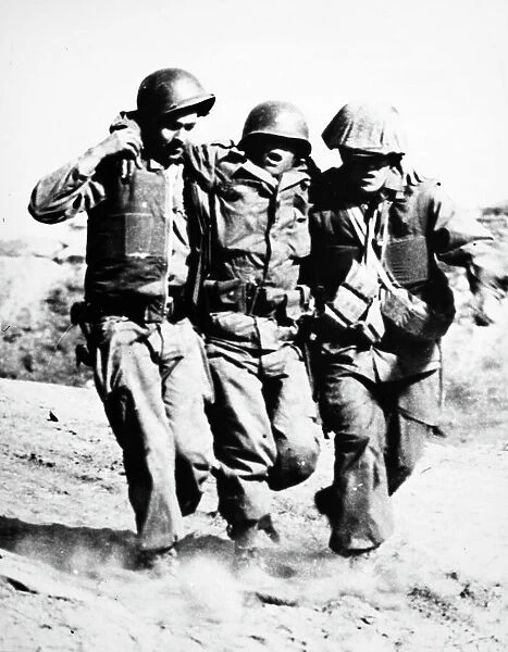 KOREAN WAR: PORK CHOP HILL. An American soldier, wounded at the Battle of Pork Chop Hill in 1953, receives assistance from two comrades