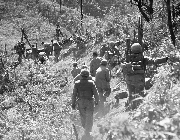 KOREAN WAR: TRIANGLE HILL. After enemy artillery has disrupted the Allied trolley system, litter bearers carry an injured soldier down, October 1952