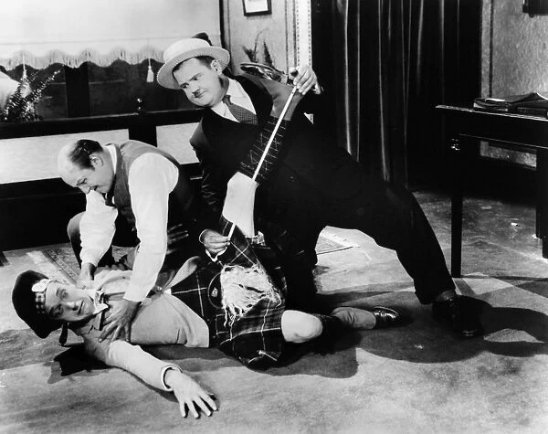 LAUREL AND HARDY, 1927. Stan Laurel (on floor) and Oliver Hardy (right) in a scene from Putting Pants on Philip, their first film as a comedy duo, 1927, directed by Hal Roach
