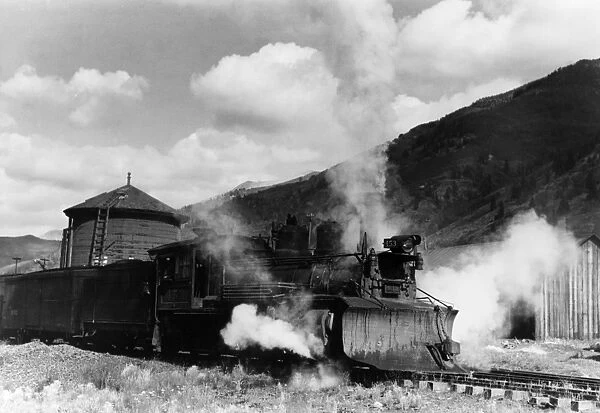 LOCOMOTIVE, 1940. Locomotive with a snowplow attached to the front of a narrow