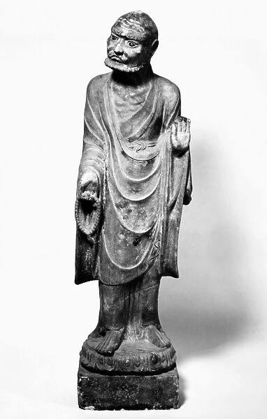 A lohan holding prayer beads in one hand, with the other raised in a preaching gesture. Marble. Height: 42 in. Jin Dynasty, northern China, 1180