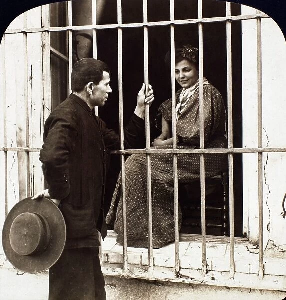 LOVE, 20th CENTURY. Lovers in Andalusia, Spain, flirting through a barred window. American stereograph, early 20th century