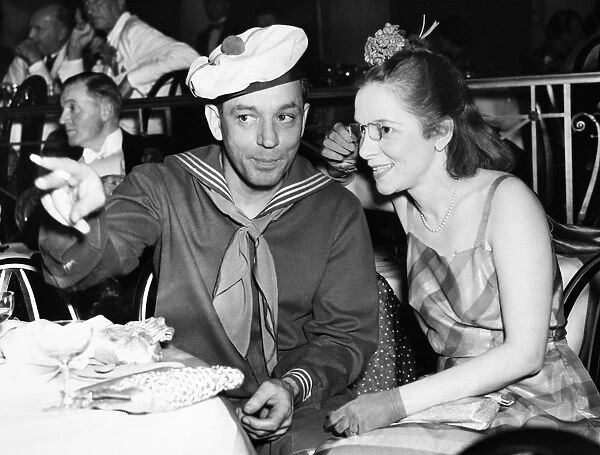 MACARTHUR & HAYES, 1937. American journalist and playwright Charles MacArthur and his wife, actress Helen Hayes, at the Red, White and Blue Burlesque Ball given for gossip columnist and hostess Elsa Maxwell, in the Empire Room of the Waldof-Astoria in New York City, 16 April 1937