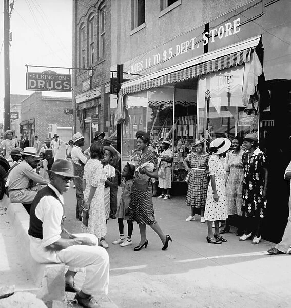 MAIN STREET SHOPPERS, 1939. African American men and women shopping and socializing