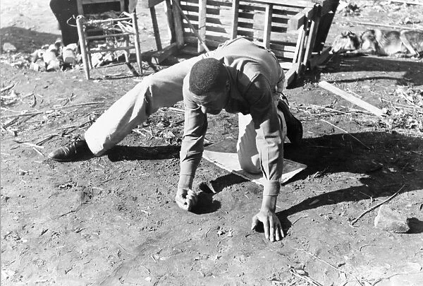 MARBLE GAME, 1940. An African American man playing a game of marbles. Photographed in Eufaula