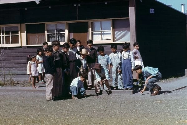 MARBLE GAME, 1942. Group of boys playing marbles at a Farm Security Administration