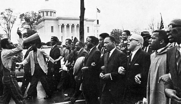 MARTIN LUTHER KING, JR. (1929-1968). American clergyman and reformer. Dr. King (fourth from right) leading the march from Selma on the state capitol at Montgomery, Alabama, 25 March 1965