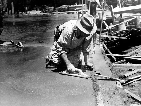 MARYLAND: WORKER, 1936. Worker using a trowel to level a cement floor, Greenbelt, Maryland