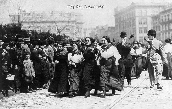 MAY DAY PARADE, 1910. A group of women marching arm-in-arm with spectators watching