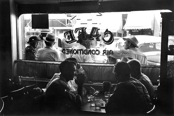 Men sitting at a table with cold drinks in a cafe at Vale, Oregon. Photograph by Russell Lee, 1941