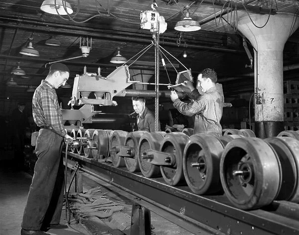 Men working on an assembly line to manufacture U. S. Army half-track scout cars in a converted truck plant in Ohio, during World War II. Photograph by Alfred Palmer, December 1941