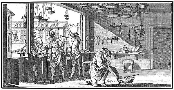 METALWORKER, 18th CENTURY. An 18th century French balance-makers shop. In the foreground a workman melts on a brazier a spoonful of lead, with the aid of a bellows, with which he will cast a weight. Line engraving, French, 18th century