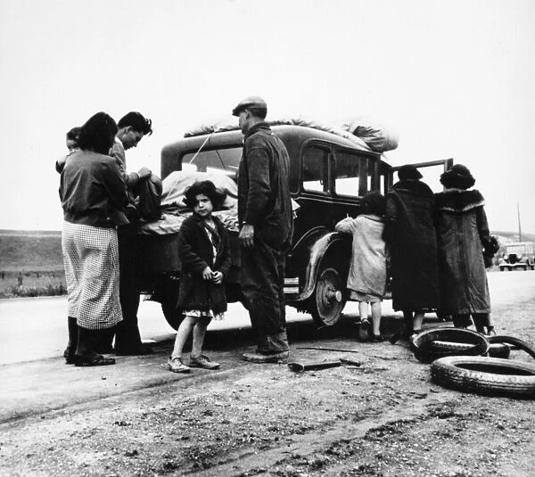 MEXICAN MIGRANTS, 1936. A Mexican family of migrant workers with a flat tire along