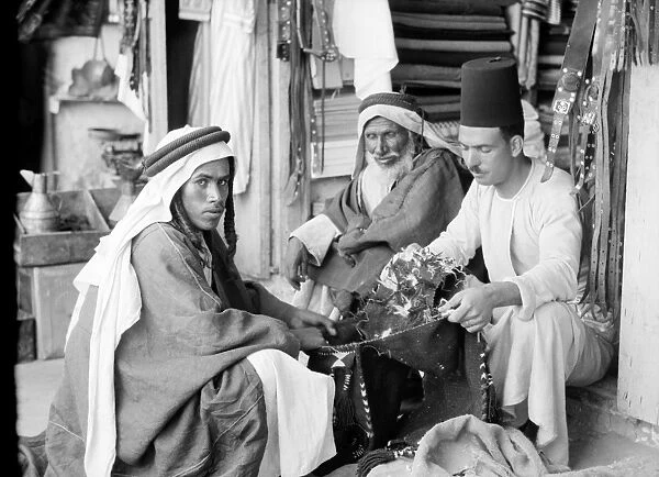MIDDLE EAST: BEDOUINS, 1932. A group of Bedouin men seated at a shop in the Middle East
