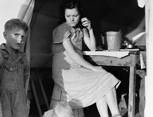 MIGRANT CAMP, 1939. A daughter and son of an ex-tenant farmer from Oklahoma living