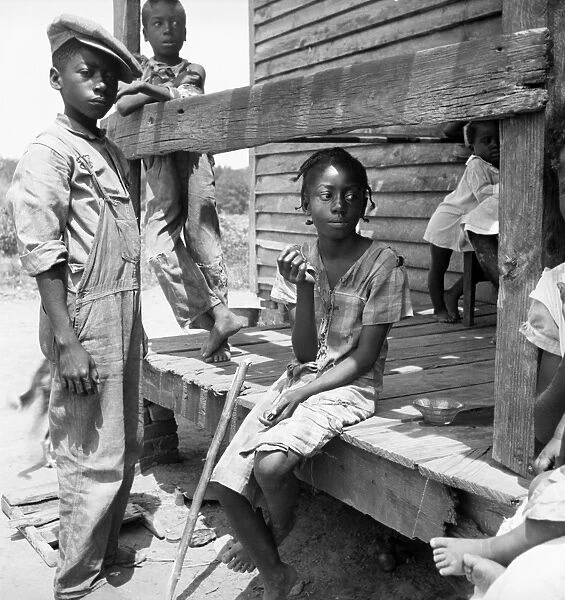 MIGRANT CHILDREN, 1936. African American children sitting on porch of a migrant