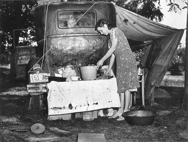 MIGRANT FAMILY, 1940. Wife of migrant worker from Arkansas preparing a meal at