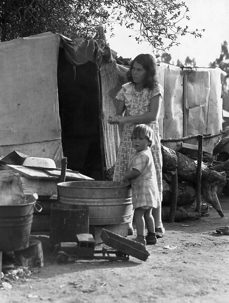 MIGRANT WORKER CAMP, 1935. Mother and child using a wash basin in a rehabilitation